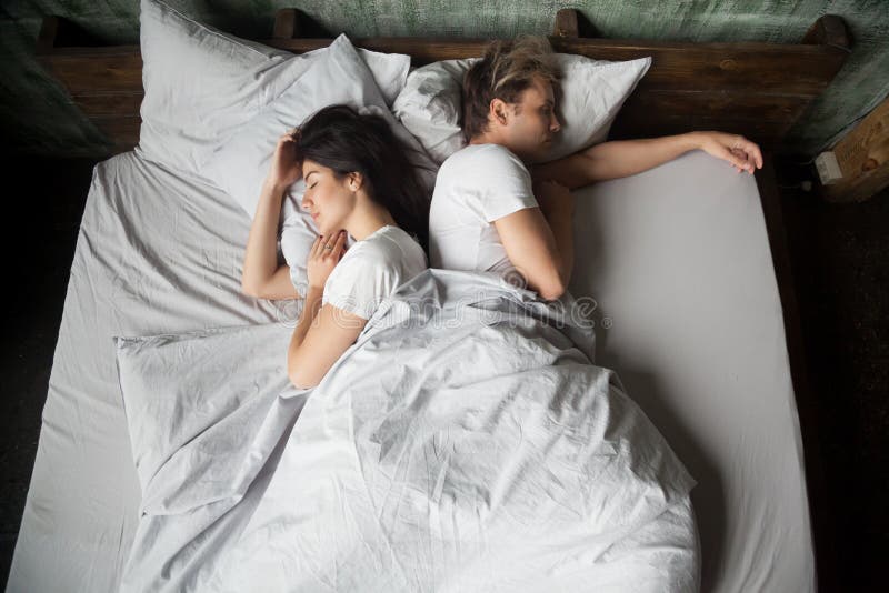 Couple under blanket sleeping in bed at home stock photo