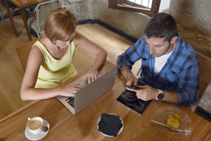 Couple using laptop computer and mobile phone networking ignoring each other royalty free stock photo Couple using laptop computer and mobile phone networking ignoring each other royalty free stock photo