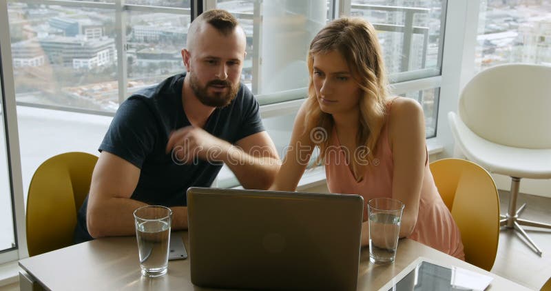 Couple using laptop in living room 4k