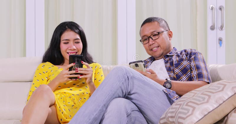 Couple using mobile phone in living room