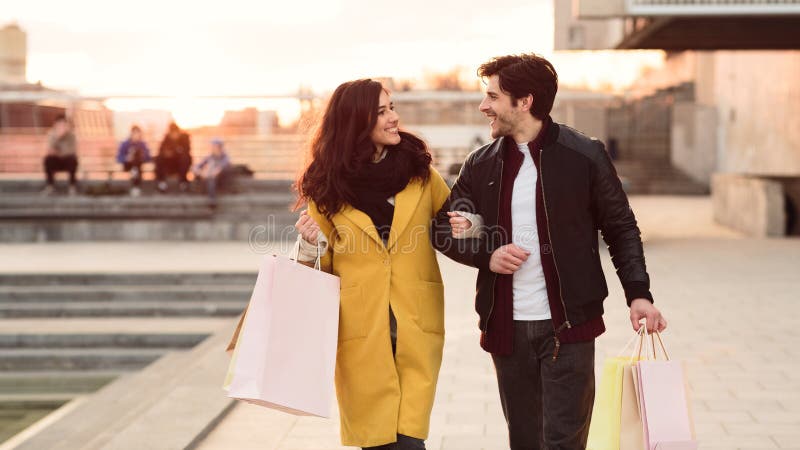 Couple walking carrying their shopping paper bags royalty free stock photos Couple walking carrying their shopping paper bags royalty free stock photos