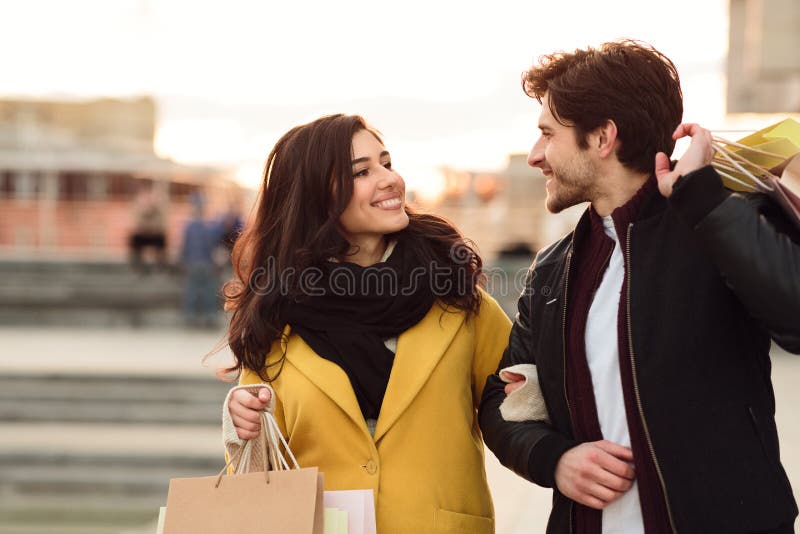 Couple walking in the city carrying shopping paper bags stock photos Couple walking in the city carrying shopping paper bags stock photos