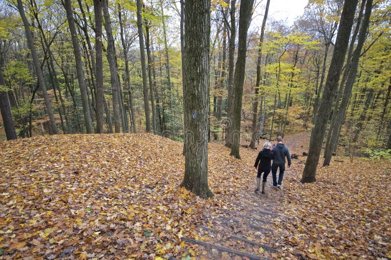 Couple walking downhill in a valley with steeps on a public park in Ontario