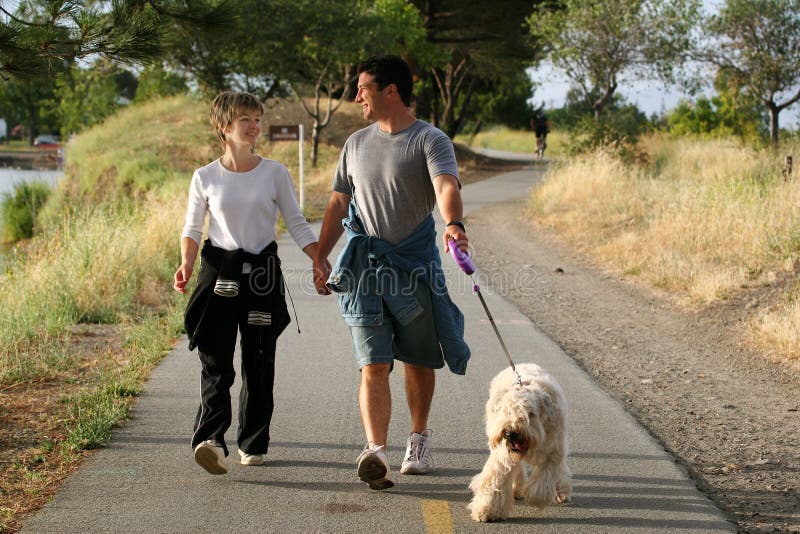 Coppia a piedi il loro cane nel parco.