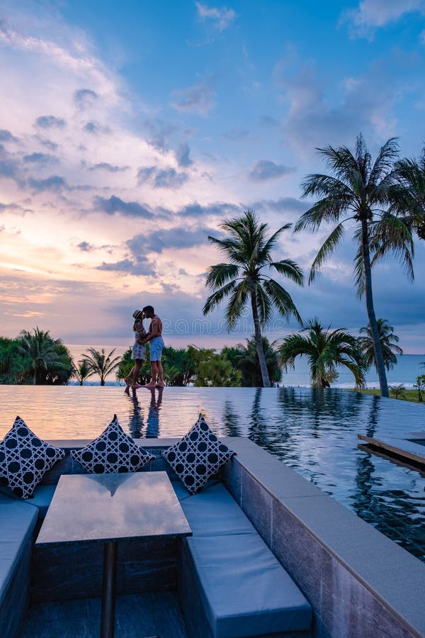 Couple Watching Sunset In Infinity Pool On A Luxury Vacation In Thailand Man And Woman Watching