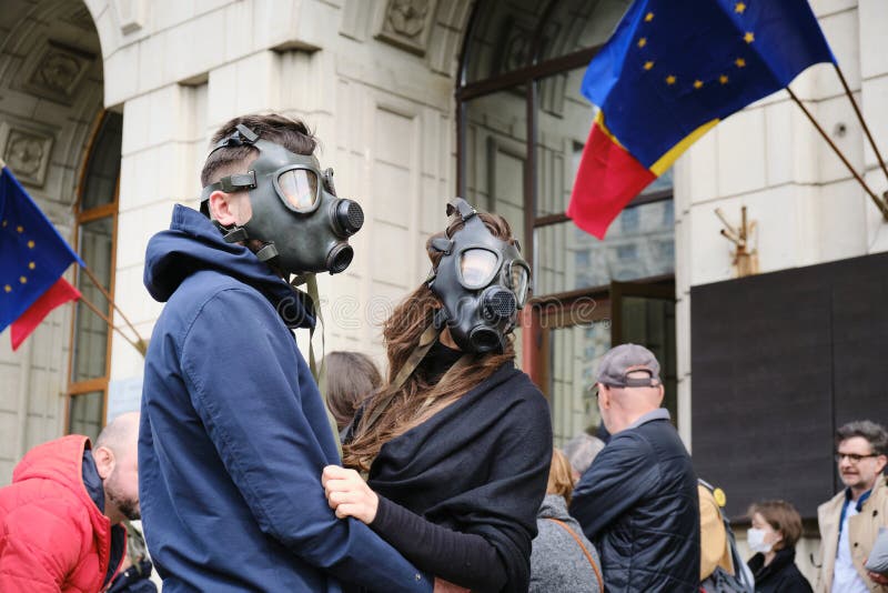 Couple wearing gas masks in protest for extreme air pollution, in front of the Ministry of Environment building