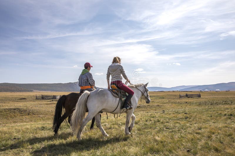 Couple riding horses in a landscape of northern Mongolia. Couple riding horses in a landscape of northern Mongolia