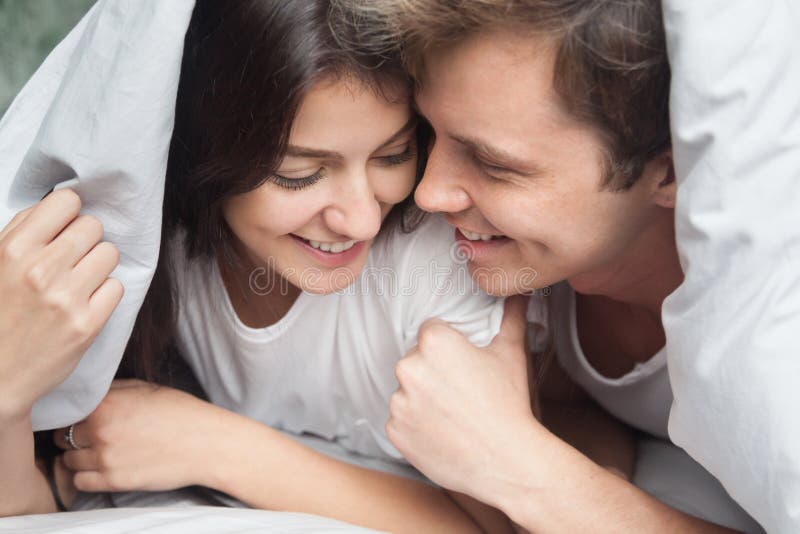 Couples affectueux heureux appréciant le moment romantique sous la couverture photo stock Couples affectueux heureux appréciant le moment romantique sous la couverture photo stock