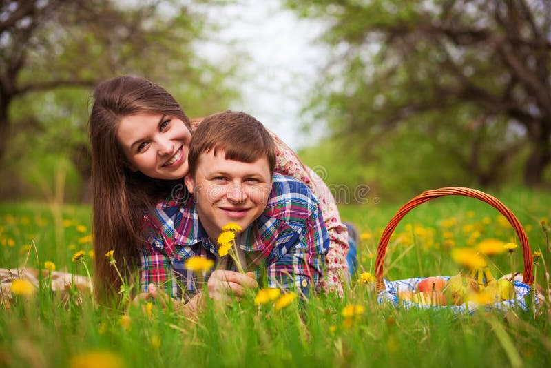 Couples affectueux heureux sur un pré de ressort photo libre de droits Couples affectueux heureux sur un pré de ressort photo libre de droits