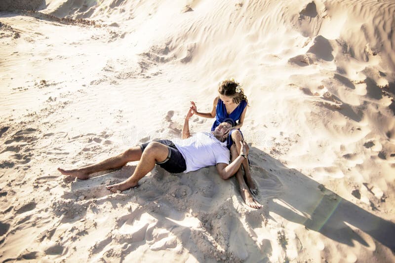Couples aimants sur la plage dans étreindre de sable Le concept de l'amour et une date en mer image libre de droits Couples aimants sur la plage dans étreindre de sable Le concept de l'amour et une date en mer image libre de droits
