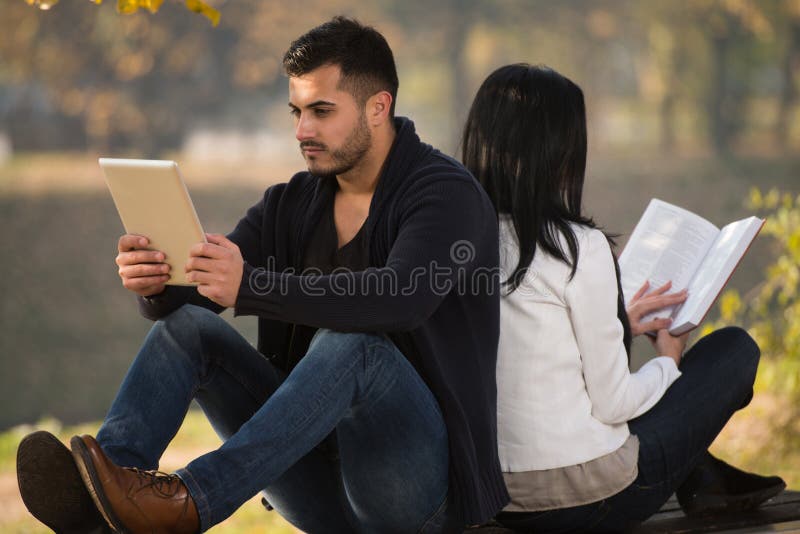 Couples appréciant la Tablette et le livre de Digtial photos libres de droits Couples appréciant la Tablette et le livre de Digtial photos libres de droits