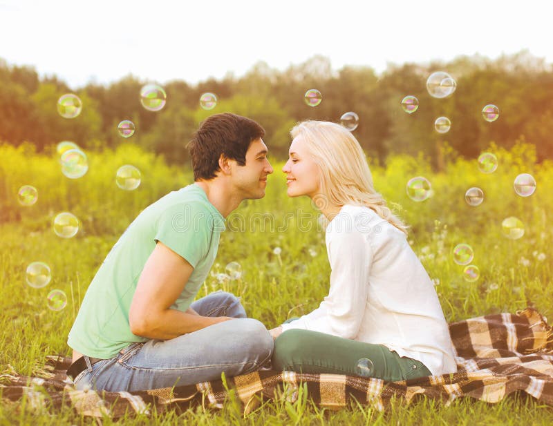 Couples assez romantiques dans l'amour ayant des bulles de savon d'amusement images stock Couples assez romantiques dans l'amour ayant des bulles de savon d'amusement images stock