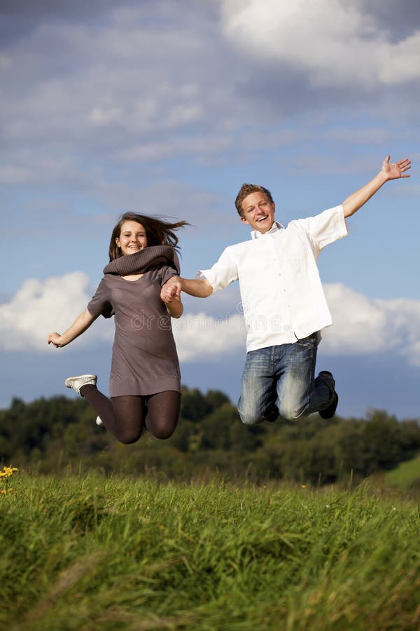 Jeune couple adolescent heureux qui saute photos libres de droits