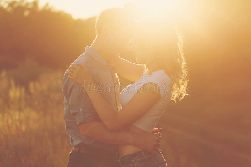 Couples dans l'amour au coucher du soleil photographie stock libre de droits Couples dans l'amour au coucher du soleil photographie stock libre de droits