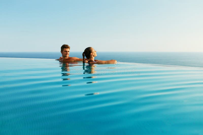 Couples dans l'amour dans la piscine de lieu de villégiature luxueux des vacances d'été romantiques photographie stock libre de droits
