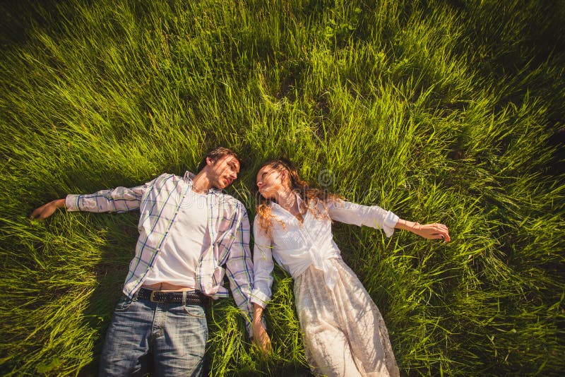 Couples dans l'amour se trouvant sur l'herbe photos libres de droits Couples dans l'amour se trouvant sur l'herbe photos libres de droits