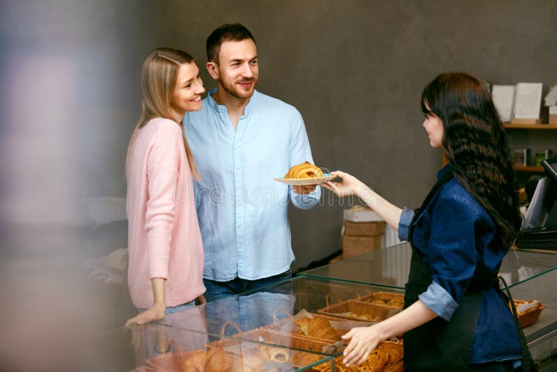 Couples dans la boutique de boulangerie Belles personnes choisissant la pâtisserie