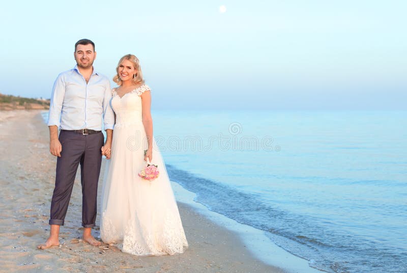 Couples de mariage se tenant sur la plage photo stock Couples de mariage se tenant sur la plage photo stock
