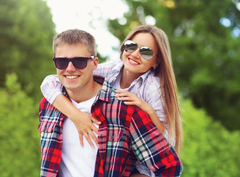Couples de sourire doux heureux dans des lunettes de soleil étreignant ayant l'amusement ensemble à l'été image libre de droits Couples de sourire doux heureux dans des lunettes de soleil étreignant ayant l'amusement ensemble à l'été image libre de droits