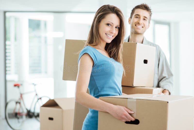 Couples de sourire déménageant une nouvelle maison photo stock Couples de sourire déménageant une nouvelle maison photo stock