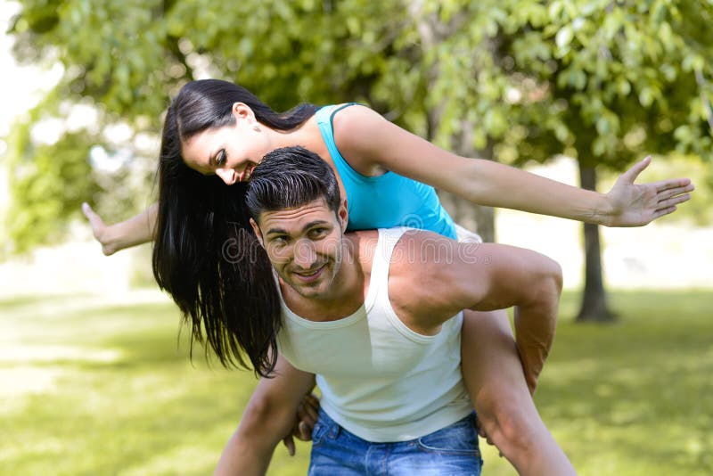 Couples de sourire heureux en parc urbain image stock Couples de sourire heureux en parc urbain image stock