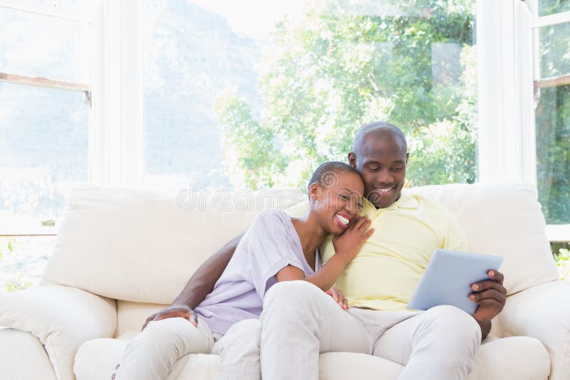 Download Couples De Sourire Heureux Utilisant L'ordinateur Portable Sur Le Divan Image stock - Image du adulte, amour: 56485147