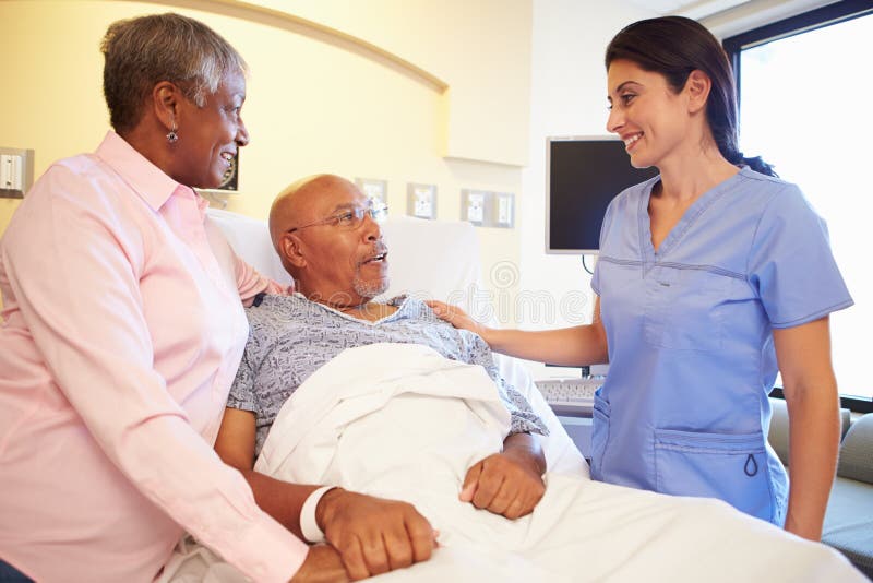Couples de Talking To Senior d'infirmière dans la chambre d'hôpital image libre de droits Couples de Talking To Senior d'infirmière dans la chambre d'hôpital image libre de droits