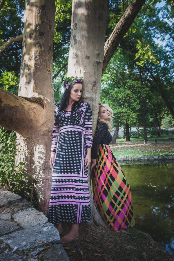 Couples des femmes de style de boho en longues robes et guirlande des fleurs image libre de droits Couples des femmes de style de boho en longues robes et guirlande des fleurs image libre de droits
