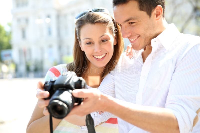 Couples des touristes employant l'appareil-photo de photo images stock Couples des touristes employant l'appareil-photo de photo images stock