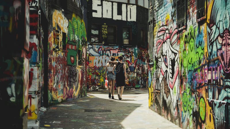 Couples descendant la rue de graffiti photo stock Couples descendant la rue de graffiti photo stock