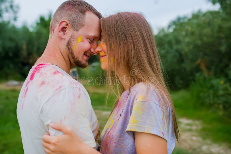 Couples en peintures multicolores étreignant dans le pré d'été Vue de c?t? image libre de droits Couples en peintures multicolores étreignant dans le pré d'été Vue de c?t? image libre de droits
