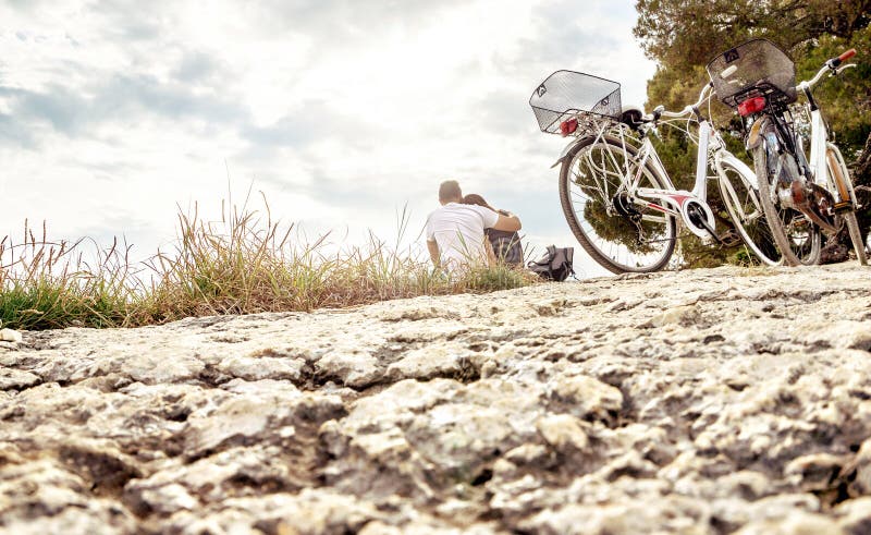Couples en voyage de vélo Amants s'asseyant sur la plage photos libres de droits Couples en voyage de vélo Amants s'asseyant sur la plage photos libres de droits