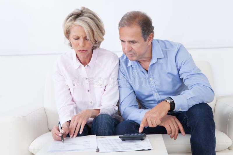 Couples faisant des finances de famille à la maison images libres de droits Couples faisant des finances de famille à la maison images libres de droits