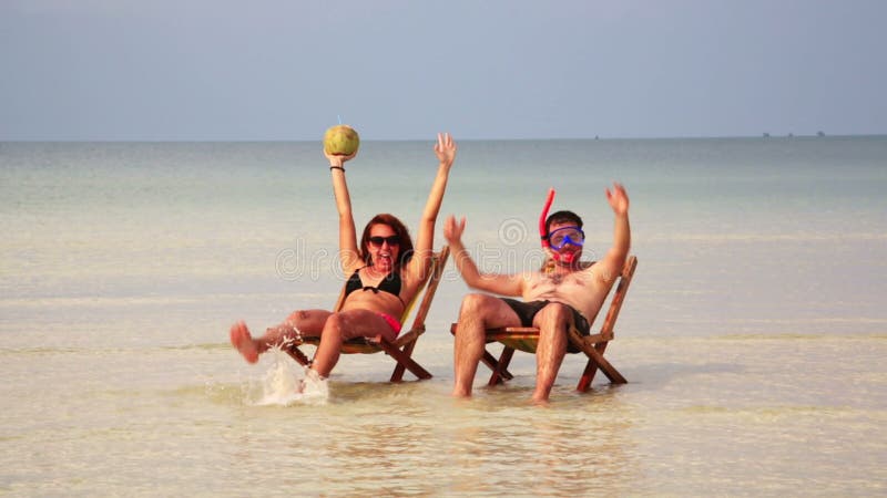 Couples fous prenant un bain de soleil à l'intérieur de l'eau en cristal fantastique