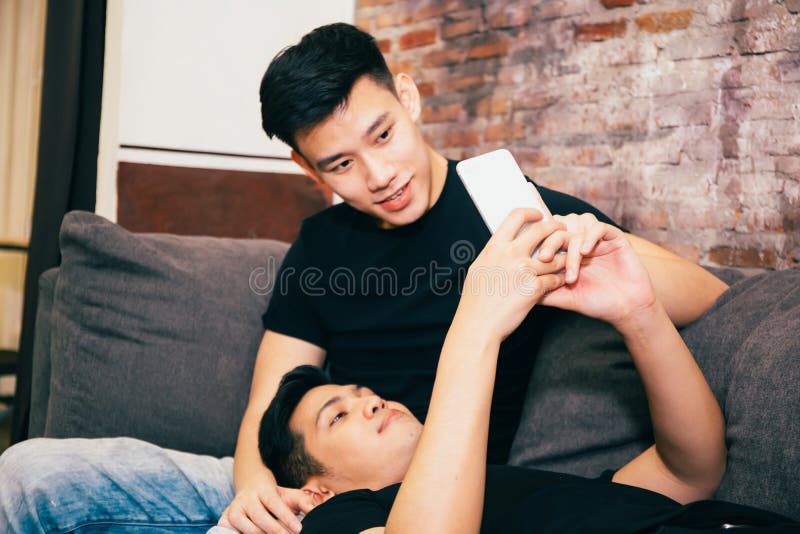 Couples gais asiatiques observant et regardant le comprimé de téléphone ensemble Portrait des homosexuels heureux - concept homos photo libre de droits Couples gais asiatiques observant et regardant le comprimé de téléphone ensemble Portrait des homosexuels heureux - concept homos photo libre de droits
