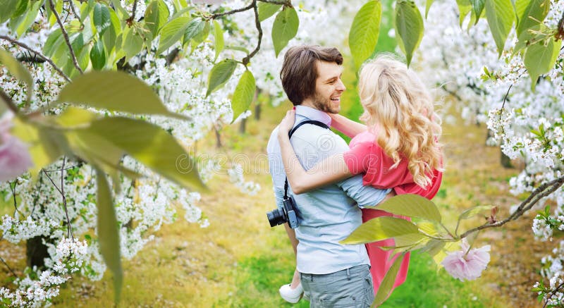 Couples gais marchant parmi des Apple-arbres image stock Couples gais marchant parmi des Apple-arbres image stock