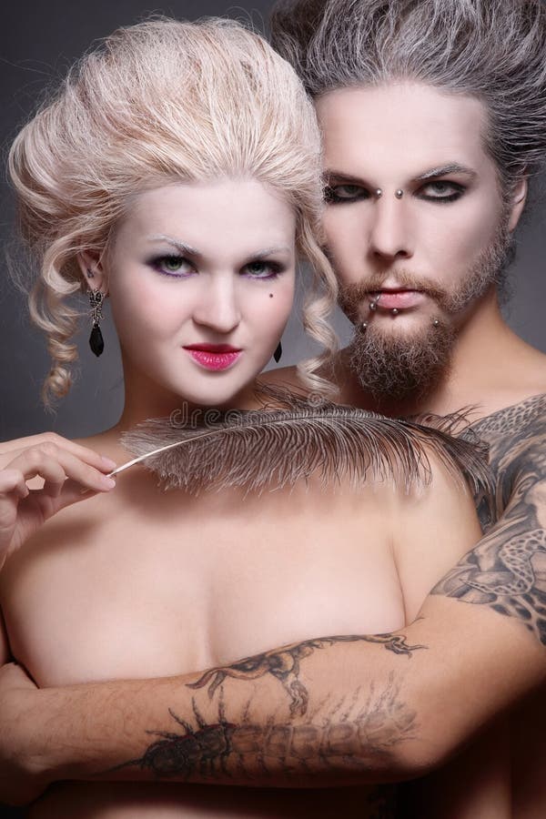 Portrait of pierced tattooed man and woman with old-fashioned make-up and hairstyle. Portrait of pierced tattooed man and woman with old-fashioned make-up and hairstyle