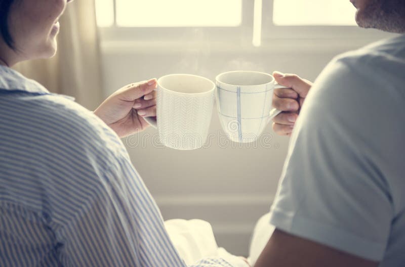 Couples heureux célébrant avec des tasses de café photo stock Couples heureux célébrant avec des tasses de café photo stock