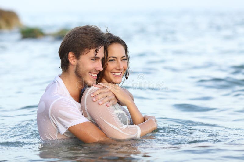 Couples heureux dans l'amour étreignant et se baignant dans la plage images stock Couples heureux dans l'amour étreignant et se baignant dans la plage images stock