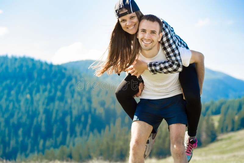 Couples heureux dans la promenade d'amour sur des montagnes Le jeune homme heureux tient son amie photo libre de droits Couples heureux dans la promenade d'amour sur des montagnes Le jeune homme heureux tient son amie photo libre de droits