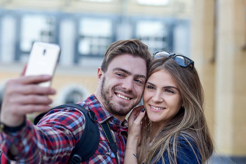 Happy couple of tourists taking selfie in showplace of city. Man and women making photo on city background. Happy couple of tourists taking selfie in showplace of city. Man and women making photo on city background.