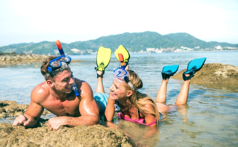 Couples heureux des vacances dans l'amour ayant l'amusement à l'eau sur la plage tropicale en Thaïlande avec le masque de prise d photos libres de droits Couples heureux des vacances dans l'amour ayant l'amusement à l'eau sur la plage tropicale en Thaïlande avec le masque de prise d photos libres de droits