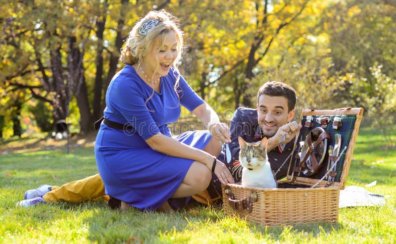 Couples heureux et souriants enceintes sur le pique-nique avec le chat photos libres de droits Couples heureux et souriants enceintes sur le pique-nique avec le chat photos libres de droits