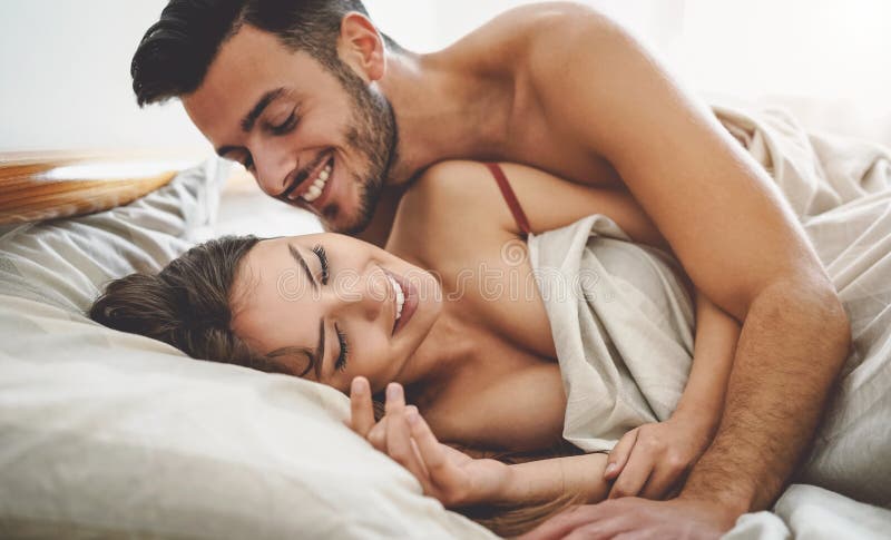 Couples heureux s'amusant sur le lit sous le tapis images libres de droits