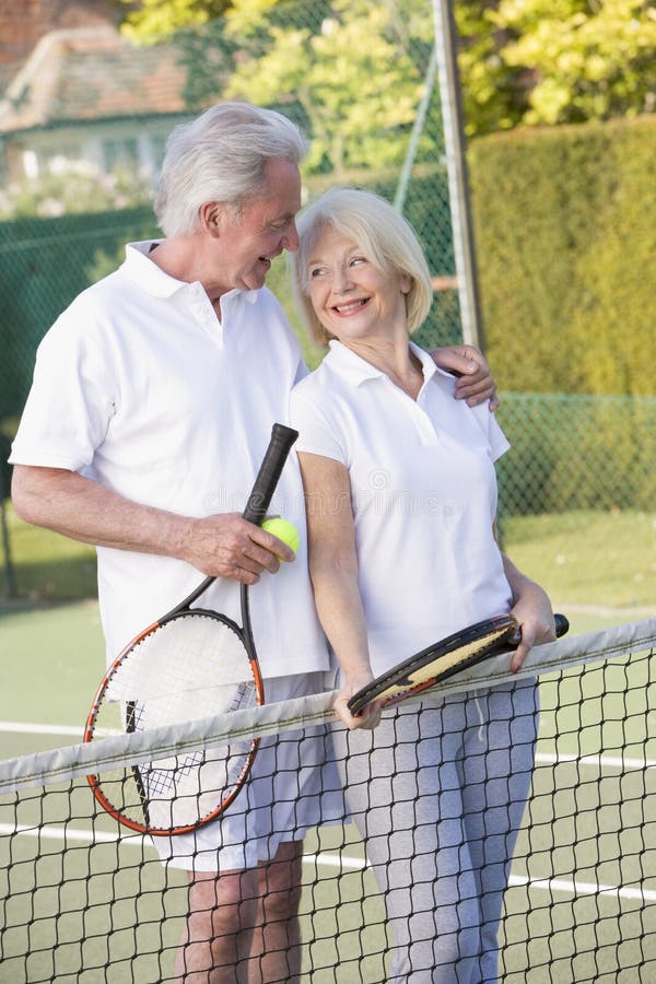 Couples jouant le tennis et le sourire images libres de droits Couples jouant le tennis et le sourire images libres de droits