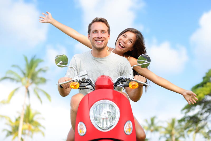 Couples libres heureux de liberté conduisant le scooter image stock Couples libres heureux de liberté conduisant le scooter image stock