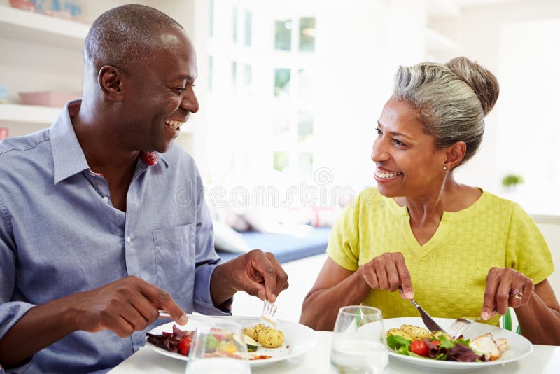 Couples mûrs d'Afro-américain mangeant le repas à la maison images libres de droits Couples mûrs d'Afro-américain mangeant le repas à la maison images libres de droits