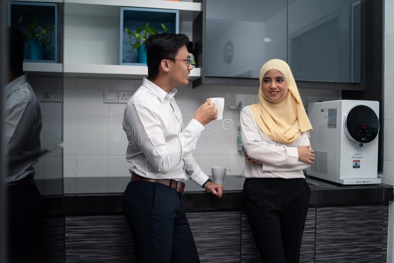 Couples malais asiatiques ayant un café dans le bureau d'office photos libres de droits Couples malais asiatiques ayant un café dans le bureau d'office photos libres de droits