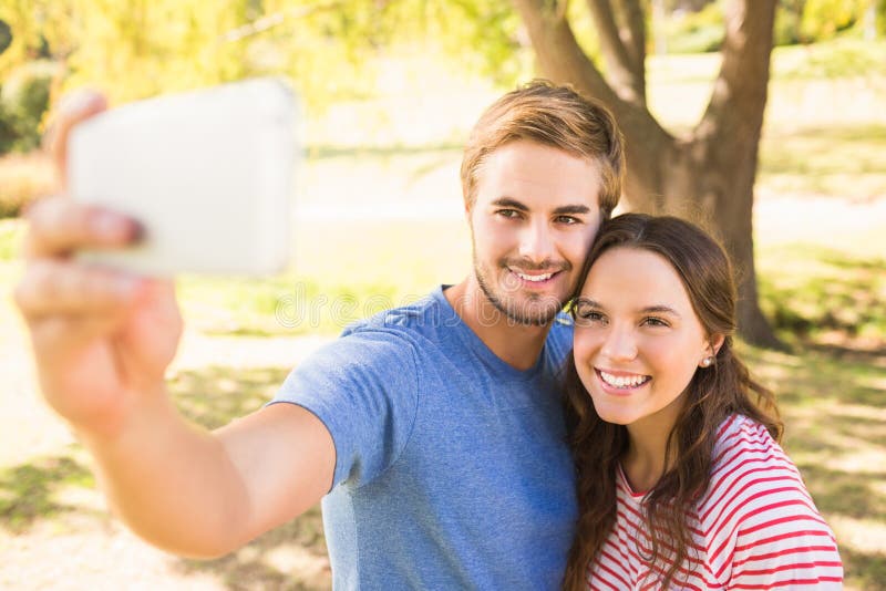 Couples mignons faisant le selfie en parc images libres de droits Couples mignons faisant le selfie en parc images libres de droits
