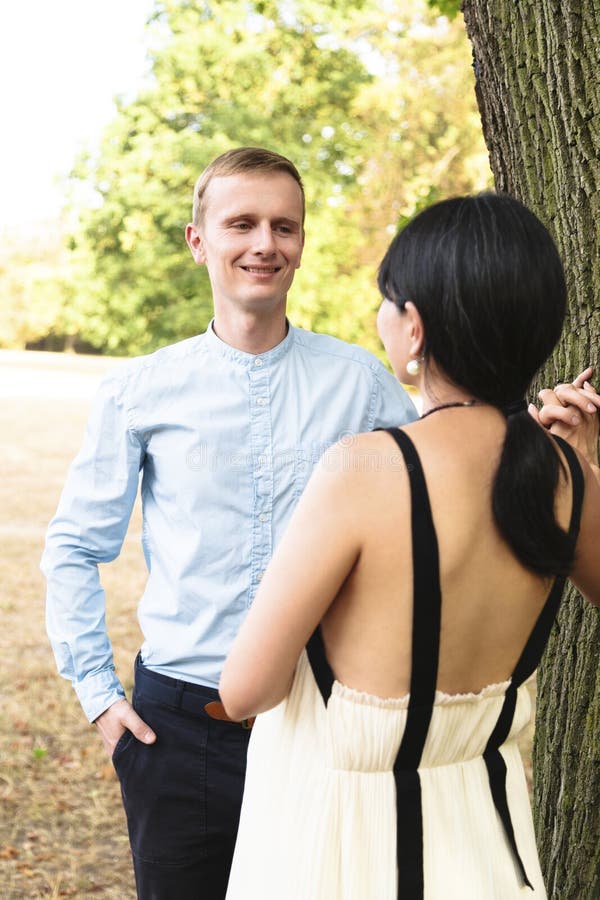 Couples multiraciaux attrayants en parc d'été marchant heureusement image stock Couples multiraciaux attrayants en parc d'été marchant heureusement image stock